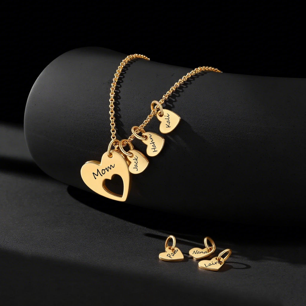 Close up of custom gold engraved mini heart charms for multi heart family name necklace