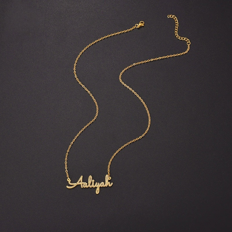 Curved cable chain display of stainless steel paved zircon cursive custom name pendant on dark background