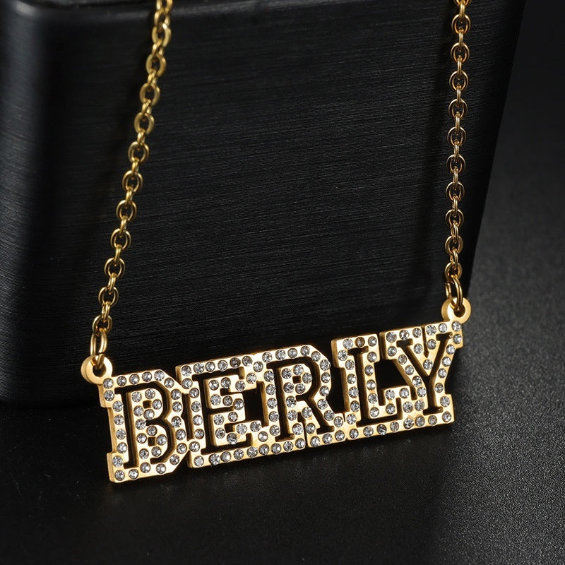 Close-up of sparkly cubic zirconia hollow block letter custom name necklace, gold personalized statement pendant jewelry