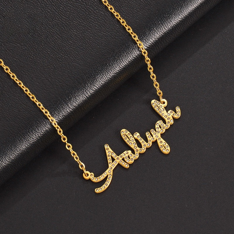 Slanted placement photo of gold stainless steel zircon cursive custom name collarbone necklace