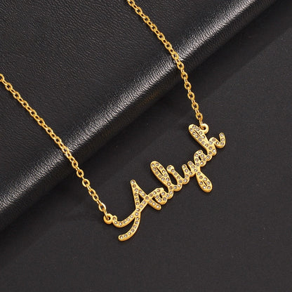 Slanted placement photo of gold stainless steel zircon cursive custom name collarbone necklace