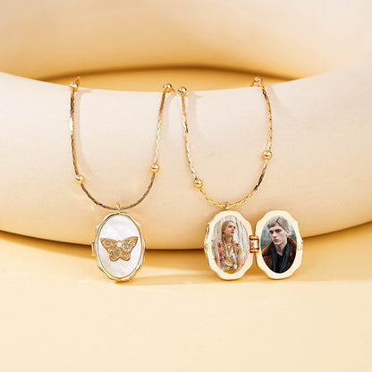 Two styles of brass natural shell butterfly photo lockets displayed together on beige silicone display stand
