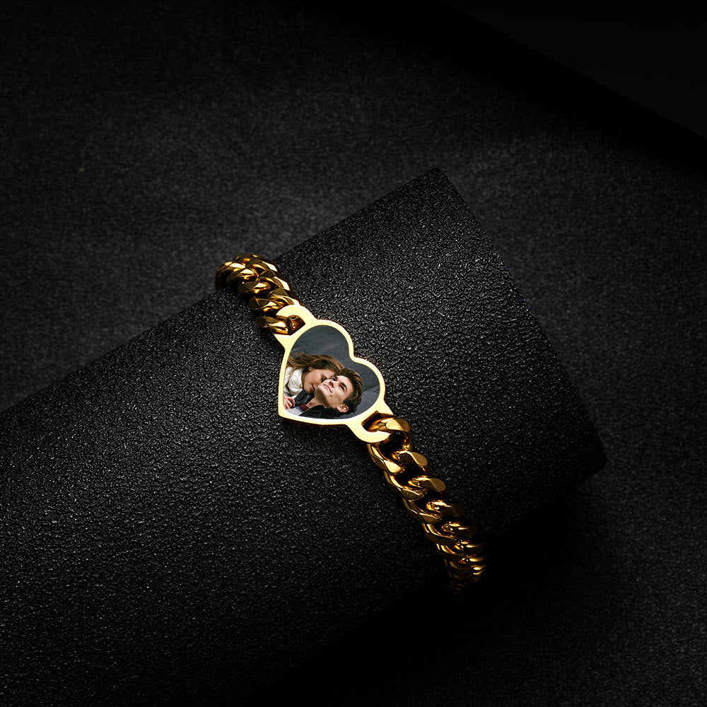 Close-up shot of gold stainless steel heart heat reactive photo bracelet on dark backdrop