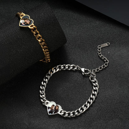 Product photo of paired gold & silver thermochromic photo bracelets laid on black fabric surface