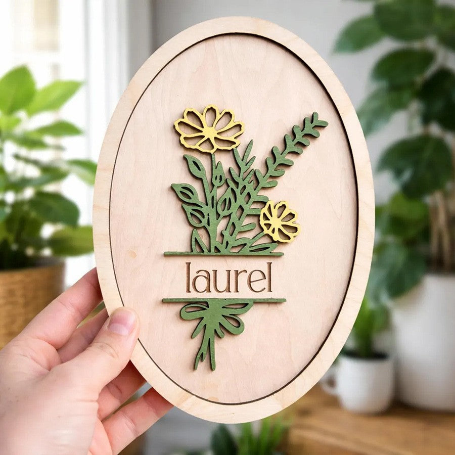 Hand holding custom engraved floral oval layered wood name plaque