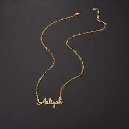 Curved cable chain display of stainless steel paved zircon cursive custom name pendant on dark background