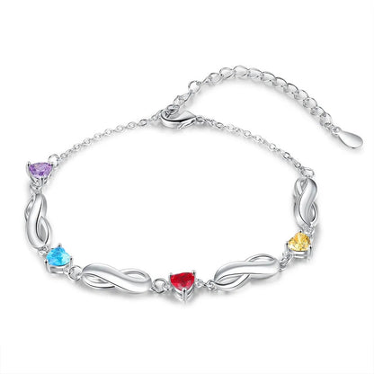 Flat product shot of adjustable brass infinity link bracelet with assorted heart cubic zirconia on white background