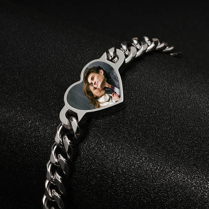Studio shot of silver stainless steel heart hidden photo memory bracelet against black background