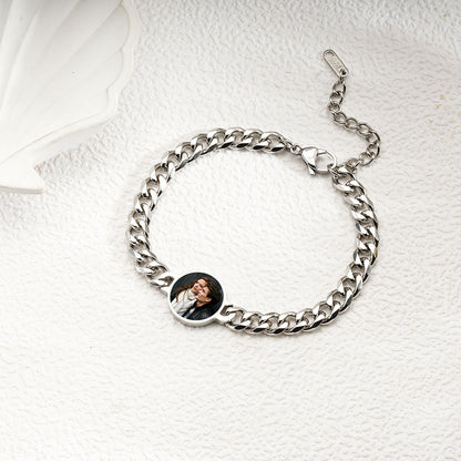 Flat lay picture of silver stainless steel adjustable bracelet with hidden custom round photo